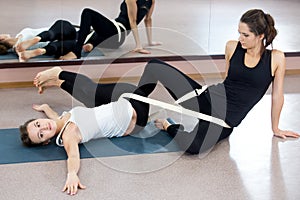 Two yogi female practicing yoga therapy in class