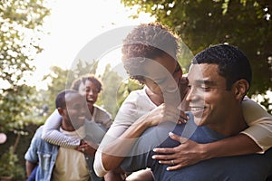 Two young adult black couples having fun piggybacking