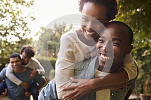 Two young adult black couples piggybacking look to camera photo