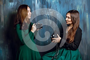 Two young adult female making photos of each others with old vintage film cameras