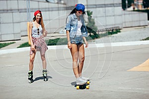 Two young adult girls riding on the street