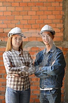 Two young architects wearing safety helmet standing construction site. Industry, Engineer, construction concept