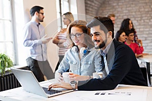 Two young architects working on laptop in office