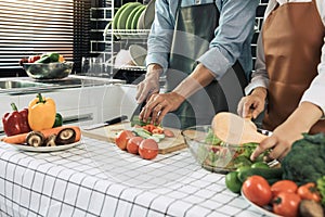 Two young asian couples are helping each other and enjoying cooking in the kitchen