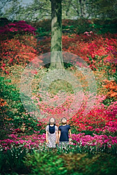 Two young asian girls meditating in colorful garden in spring