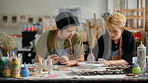 Two young Asian men join in a handicraft workshop and enjoy making clay ornaments