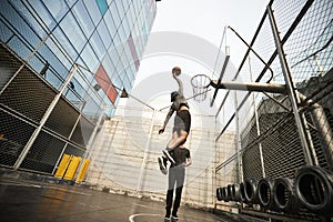 Two young asian men playing basketball outdoors