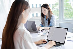 Two young asian woman are focused on working