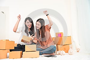 Two young Asian woman startup small business entrepreneur SME distribution warehouse with parcel mail box. Owner home office.