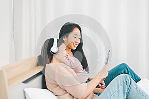 Two young asian women listening to music online at home together,Happy and smiling,Lesbian,LGBT