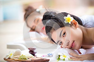 Two young Asian women relaxing in spa salon. Beauty service with friends on spa bed.
