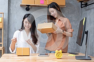 Two young Asian women startup small business entrepreneur SME distribution warehouse with parcel mail box. small  owner home