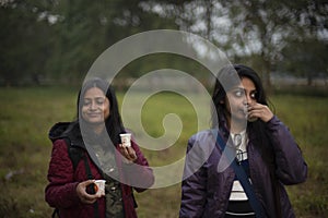 Two young Indian sisters walking in a field in winter afternoon.