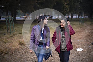 Two young Indian sisters walking in a field in winter afternoon.