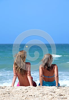 Two young attractive women chilling in the sun on holiday or vac photo