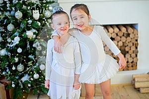 Two young ballet dancer hug near Christmas tree