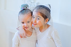 Two young ballet dancers hug