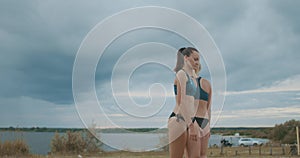 Two young beach volleyball female players are clapping hands to each other, celebrating scoring point at match