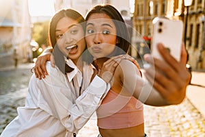 Two young beautiful funny happy asian girls taking selfie