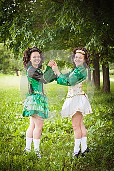 Two young beautiful girl in irish dance dress posing outdoor