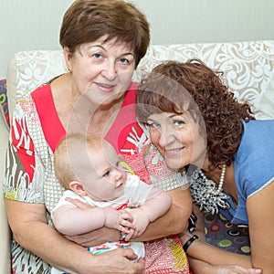 Two young beautiful grandmothers communicate with a small  granddaughter. photo