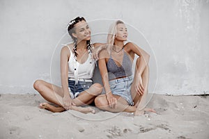 Two young beautiful happy summer girls on the beach