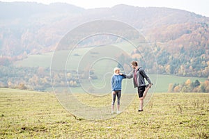 Two young beautiful runners in autumn nature, stretching legs