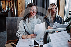 Two young beautiful women at a business meeting in a cafe