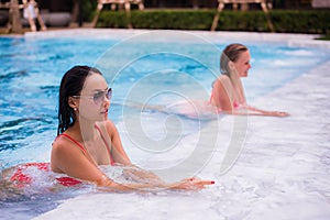 Two young beautiful women in jacuzzi of resort