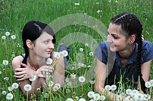 two young beautiful women relaxing at the spring meadow