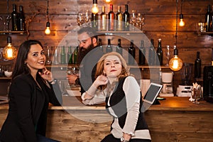 Two young beautiful women talking in the pub