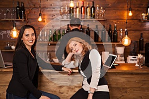 Two young beautiful women talking in the pub
