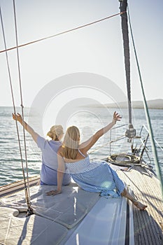 Two young blondy caucasian women meets sunrise on the yacht photo