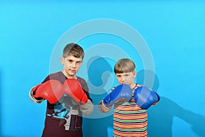 Two young boxers in boxing gloves make an attacker punch on a blue background