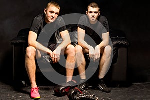 Two young boxers relax before a training session