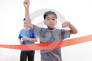 Two young boy run cross red finish line