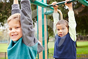 Two Young Boys On Climbing Frame In Playground