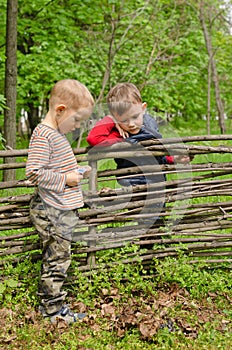 Two young boys discussing lighting a campfire