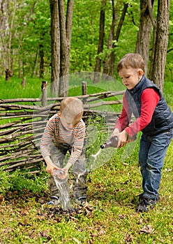 Two young boys extinguishing a small fire