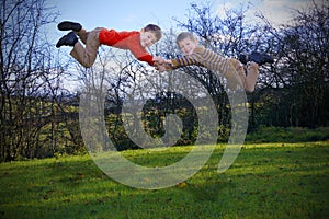 Two young boys flying outdoors