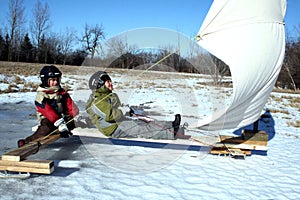 Two Young Boys On Ice Boat With Sails