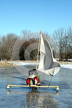 Two Young Boys On Ice Boat With Sails