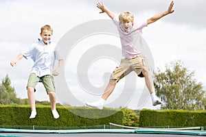 Dos joven los chicos saltando sobre el trampolín 
