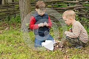 Two young boys lighting a fire outdoors