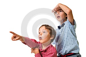 Two young boys looking ahead, surprised, pointing finger to unknown object