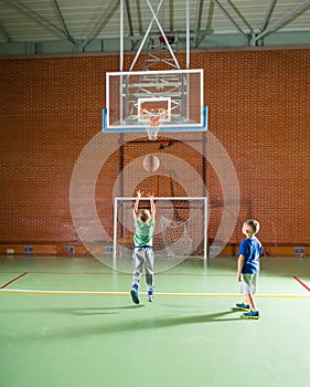 Two young boys playing basketball together