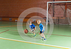 Two young boys playing a game of basketball