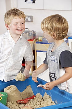 Two Young Boys Playing Together in Sandpit