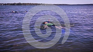 Two young boys snorkelling in a lake at the height of summer holidays. Consider for summer holiday camp footage. Carefree, young.