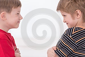 Two young boys standing face to face.